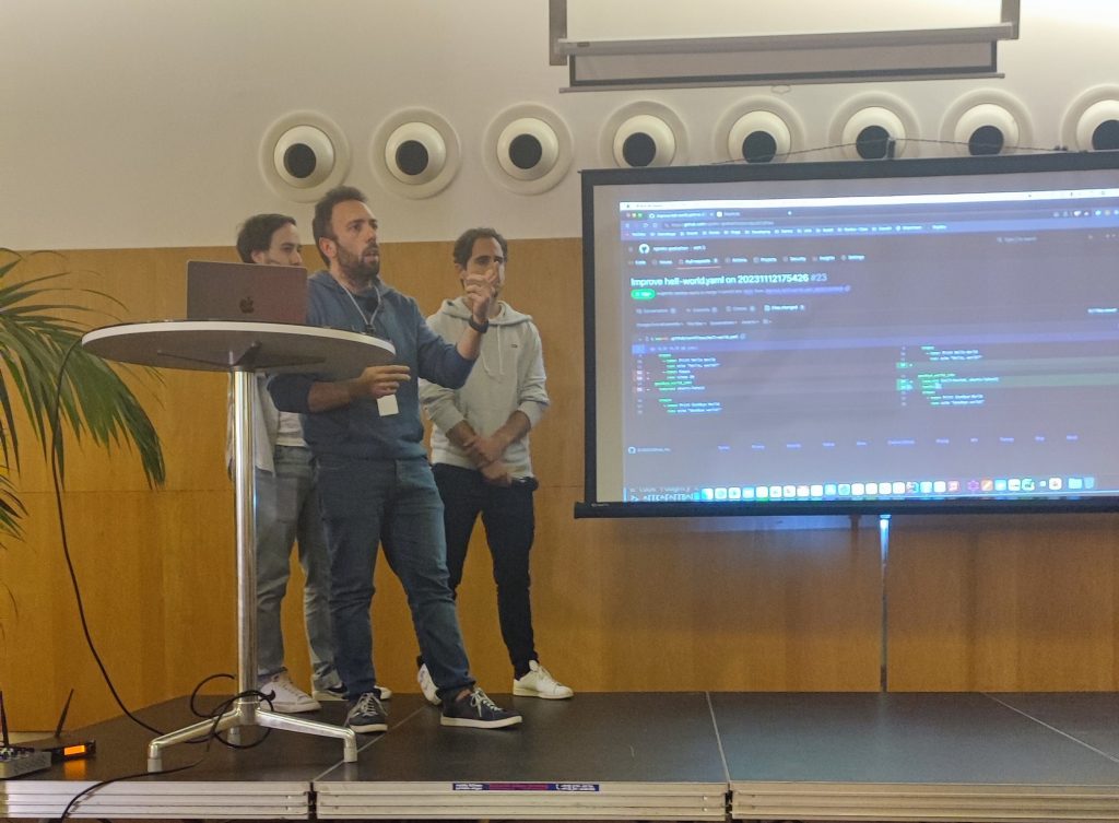 Three men giving a lecture on stage.